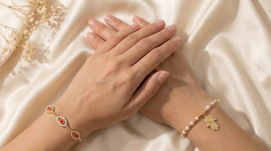 Aura Nomad featured blog banner showing a complete spiritual protection wrist stack with a red evil eye bracelet and a hamsa pearl bracelet