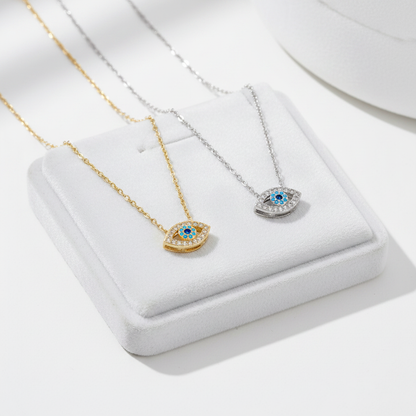Gold and silver evil eye necklaces on white velvet tray