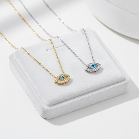 Gold and silver evil eye necklaces on white velvet tray