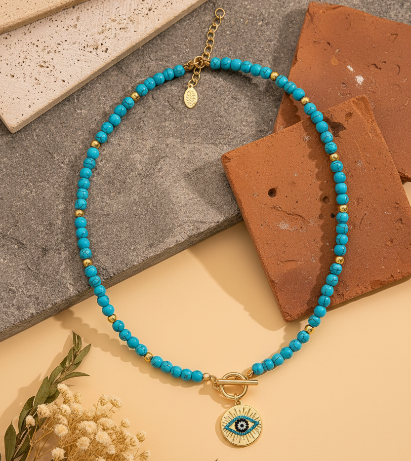 Turquoise evil eye necklace on ancient stone surface with dried botanicals