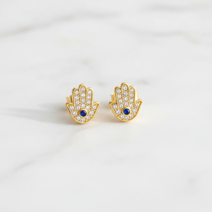 Hamsa gold stud earrings on clean white marble