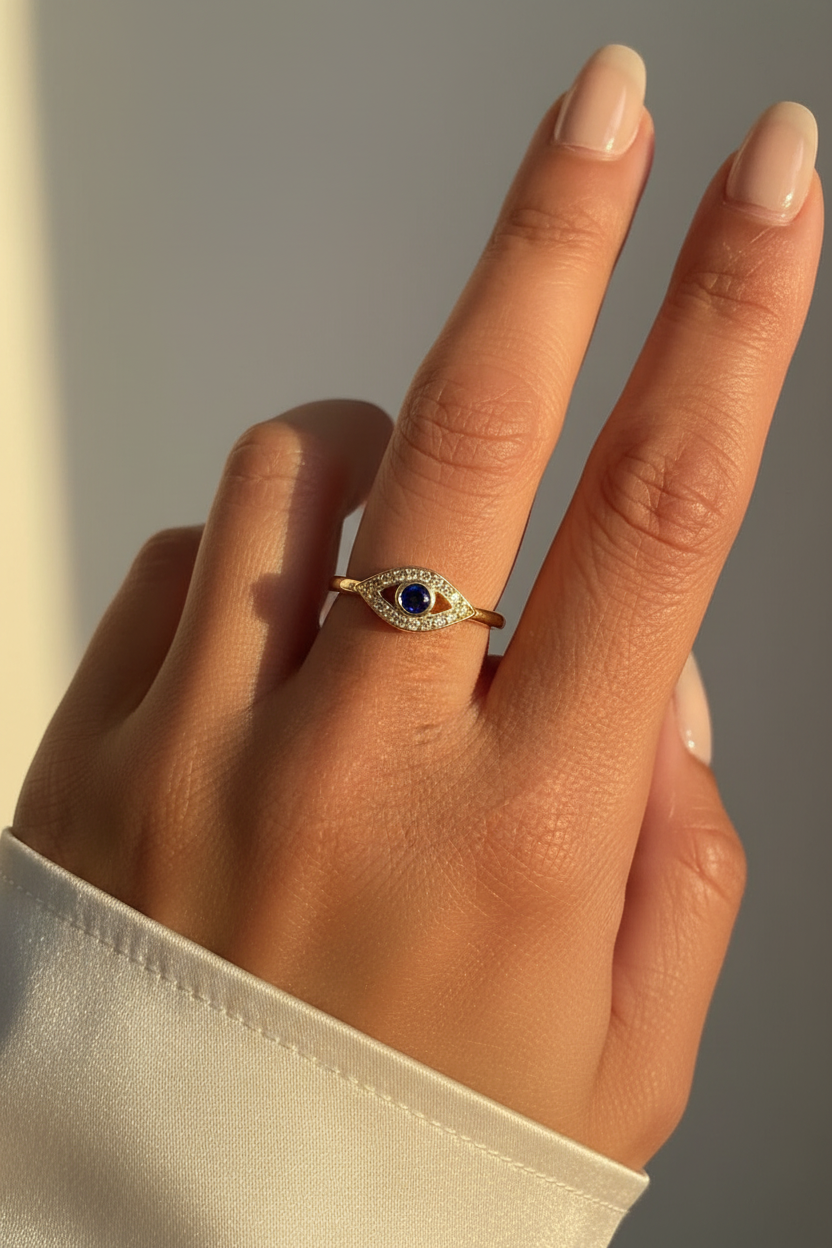Evil eye sapphire ring on young woman's hand golden hour