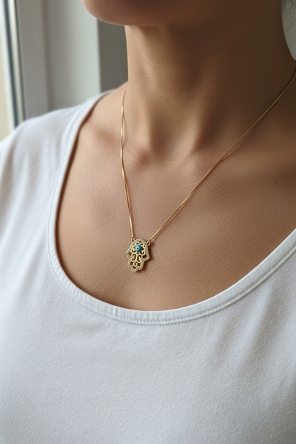 UGC lifestyle shot of hamsa evil eye necklace worn on woman in white top
