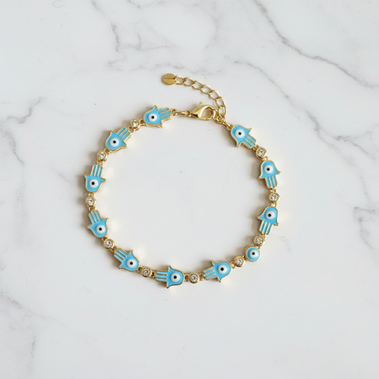 Blue hamsa evil eye bracelet on white marble