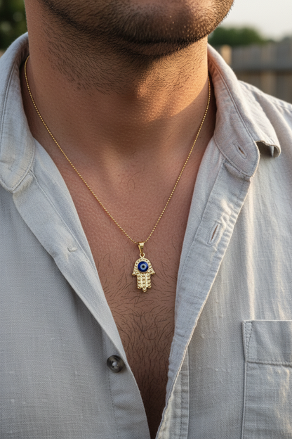 UGC lifestyle shot of gold diamond-cut hamsa necklace worn by man in linen shirt