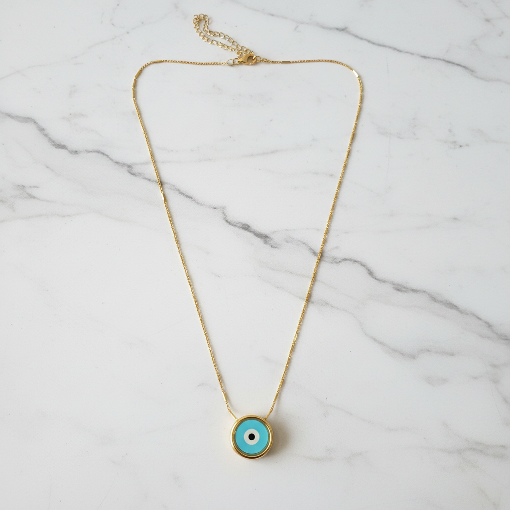 Turquoise evil eye gold necklace on white marble surface overhead showcase