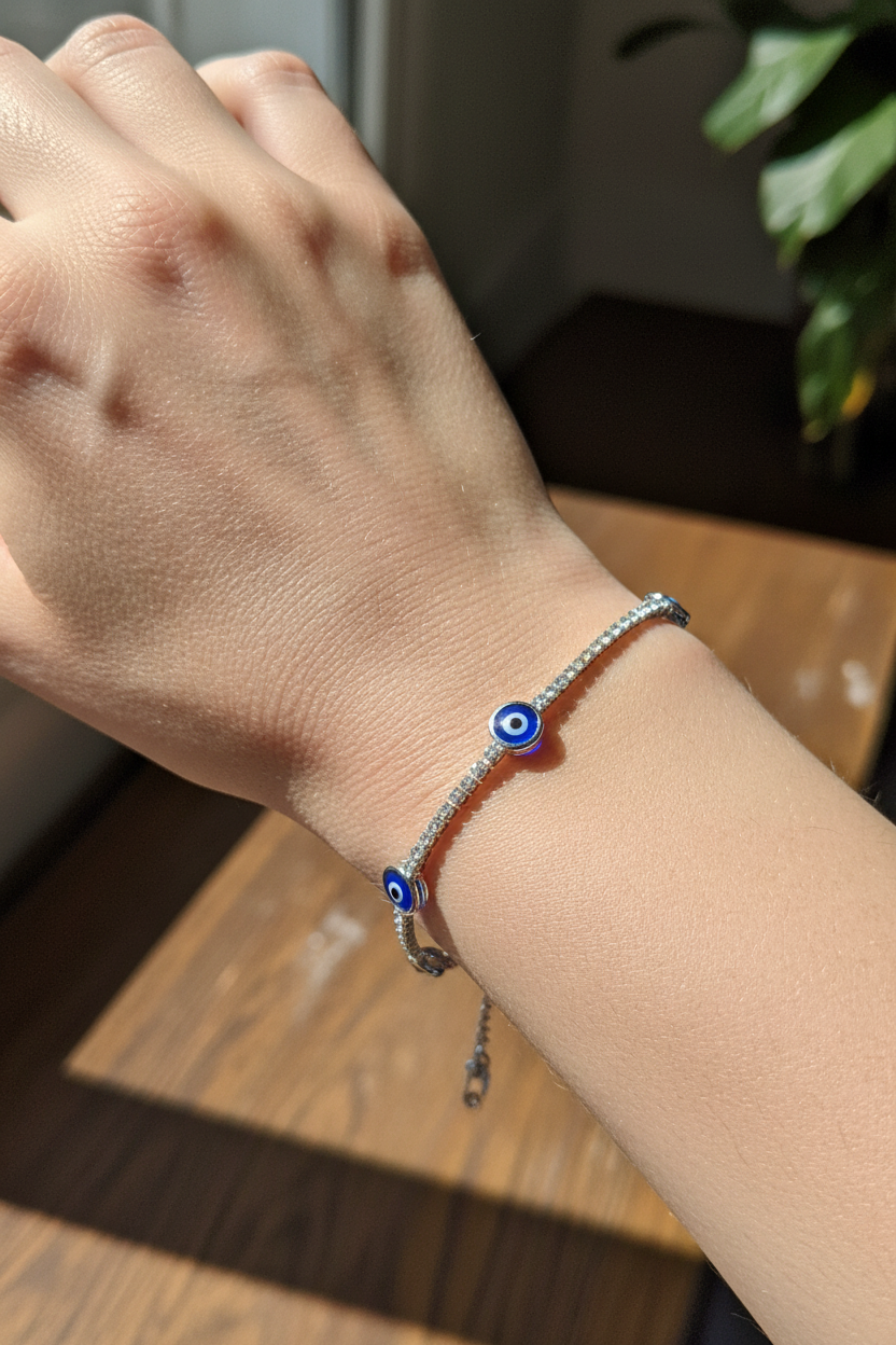 UGC lifestyle shot of silver evil eye tennis bracelet worn on light skinned woman's wrist