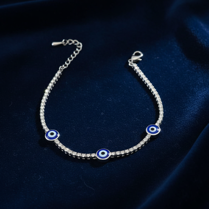 Silver evil eye tennis bracelet on dark navy velvet luxury showcase