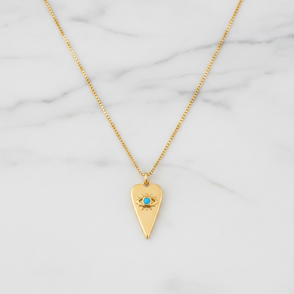 Gold heart evil eye necklace with turquoise stone flat lay on white marble