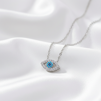 Silver evil eye zirconia necklace on white silk fabric