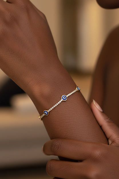 UGC lifestyle shot of gold evil eye tennis bracelet worn on dark skinned woman's wrist