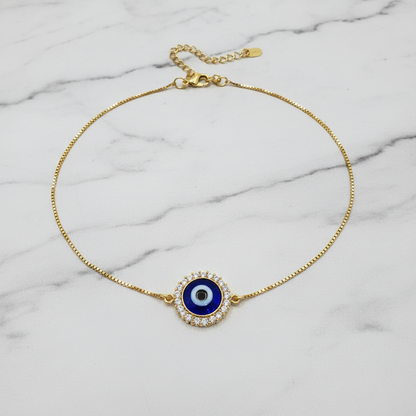 CZ evil eye halo anklet flat lay on marble