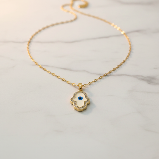 White enamel Hamsa evil eye necklace product shot on white marble