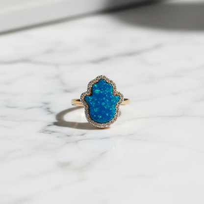 Blue opal hamsa ring flat lay marble dramatic lighting