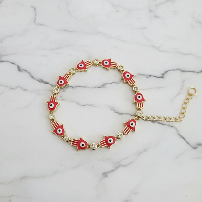 Red hamsa evil eye bracelet on white marble