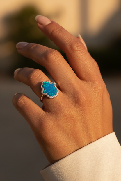 Blue opal hamsa ring on young woman's hand golden hour