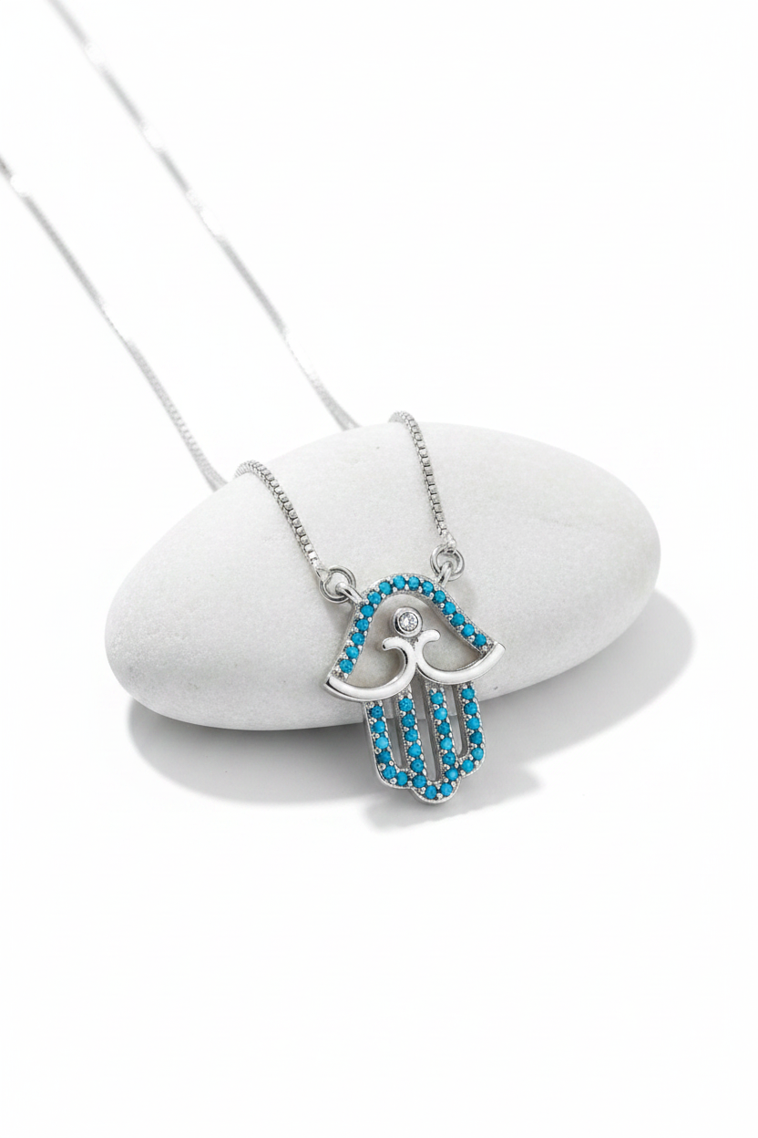 Silver turquoise hamsa necklace on white display stand, clean showcase shot