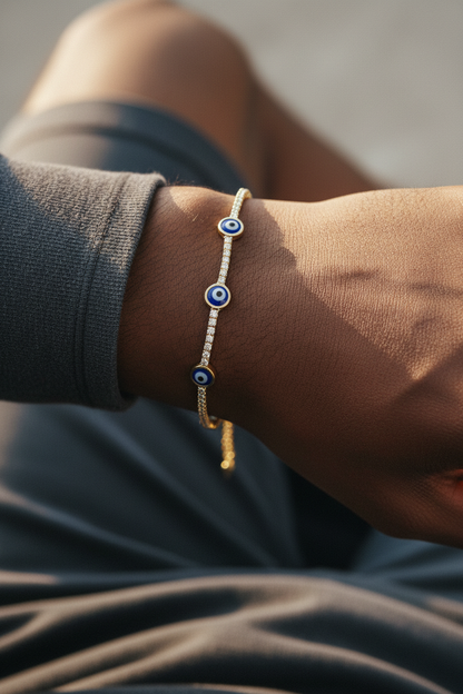 UGC lifestyle shot of gold evil eye tennis bracelet worn on dark skinned man's wrist