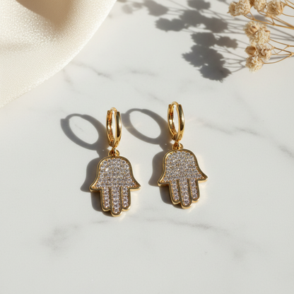 The Hamsa Hoop Earrings on white marble