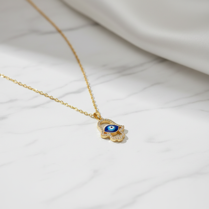 Hamsa Evil Eye Pendant Necklace on white marble background