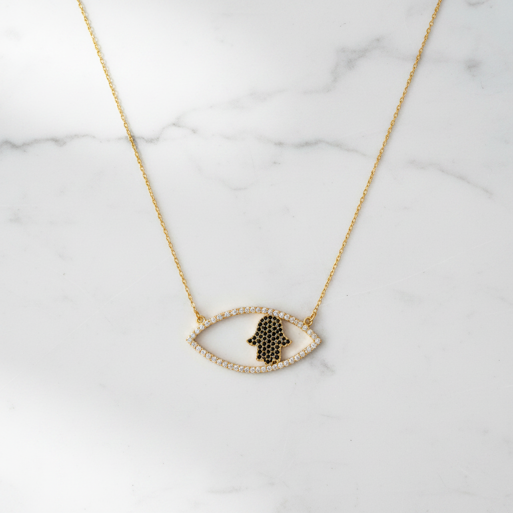 The Nazar Hamsa Necklace gold on white marble