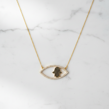 The Nazar Hamsa Necklace gold on white marble