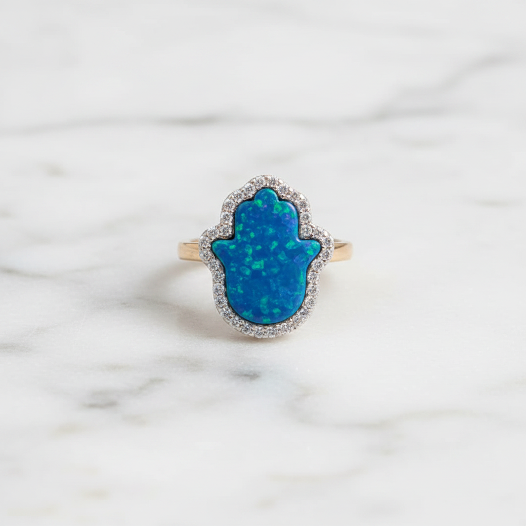 Blue opal hamsa ring flat lay on marble