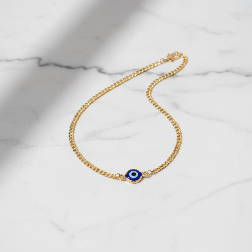 Evil eye curb chain anklet flat lay on marble