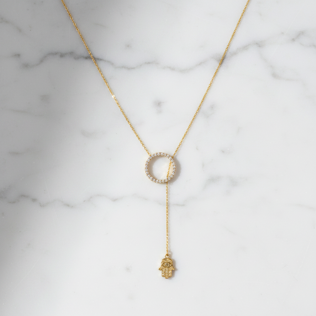 Hamsa lariat necklace on white marble