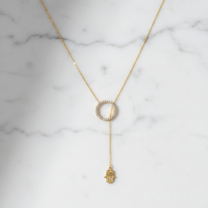 Hamsa lariat necklace on white marble