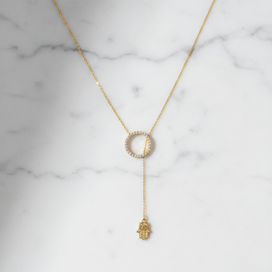 Hamsa lariat necklace on white marble
