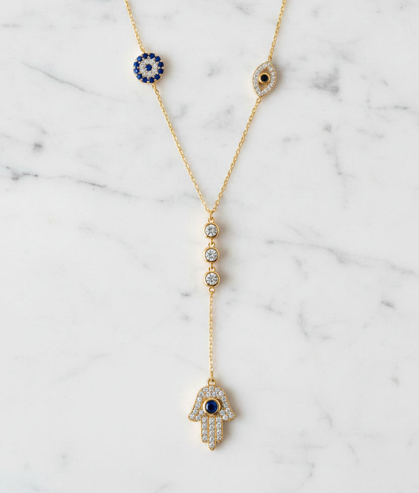 The Guardian Lariat necklace gold tone on white Carrara marble background