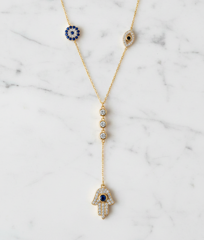 The Guardian Lariat necklace gold tone on white Carrara marble background
