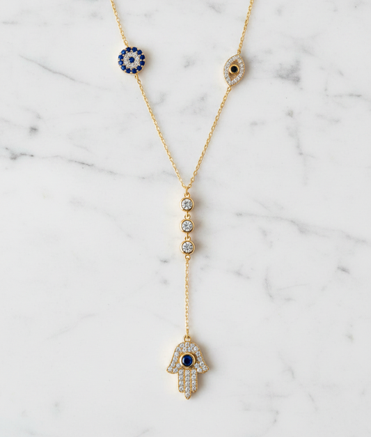 The Guardian Lariat necklace gold tone on white Carrara marble background