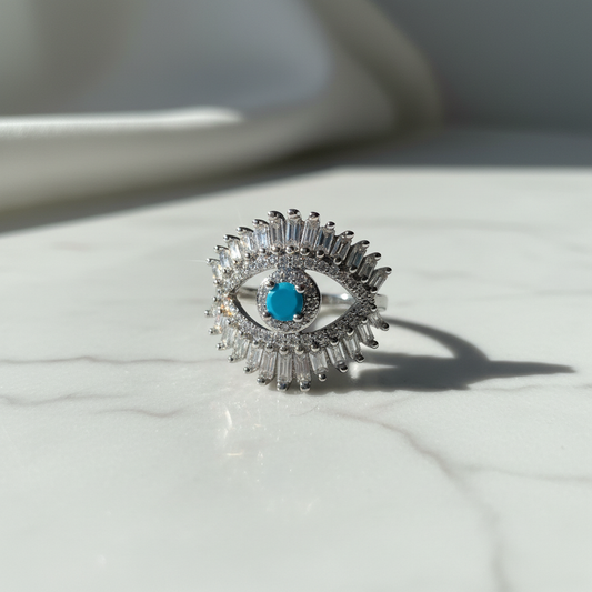 Silver baguette evil eye cocktail ring on white marble luxury showcase