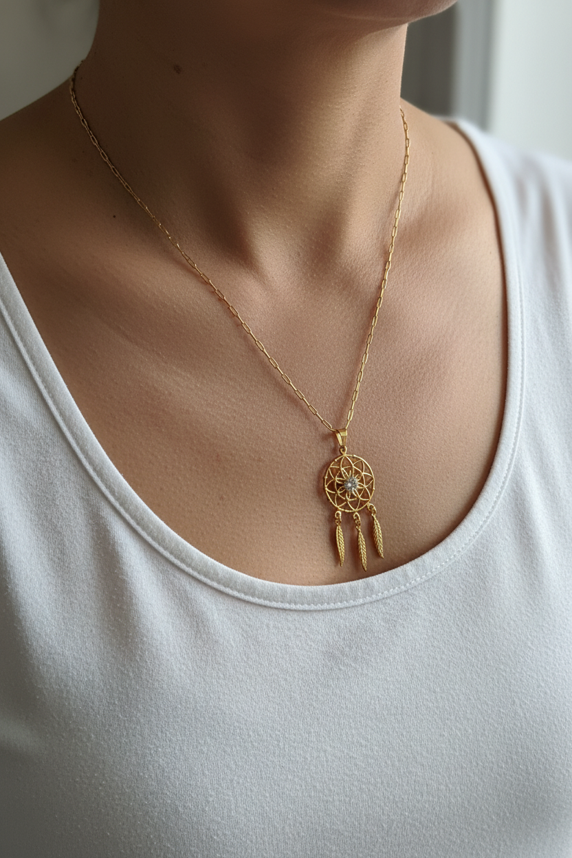 UGC lifestyle shot of gold dreamcatcher necklace worn naturally on woman in white top